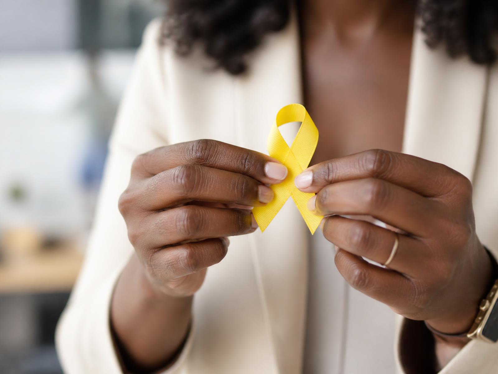 Laço amarelo do Setembro Amarelo nas mãos de uma profissional